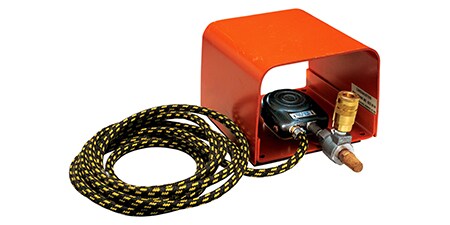 Hình ảnh một hộp bảo vệ màu da cam chứa một công tắc dùng áp lực bàn chân để kiểm soát việc bôi keo