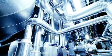 Các ống kim loại công nghiệp dài và phức tạp chạy vào nhau.
