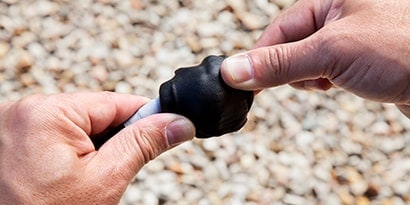 Worker applying 3M Mastic Putty to cable
