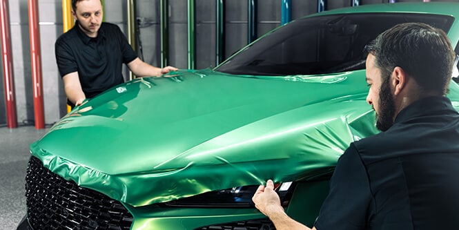 Kỹ thuật viên đang dán phim đổi màu bảo vệ sơn xe
