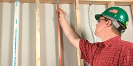 An inspector reviewing the firestop around a copper pipe going through a floor penetration
