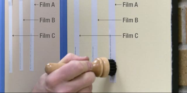 Người cầm cục tẩy gỗ trên bảng trắng được phủ phim tường có kết cấu 3M

