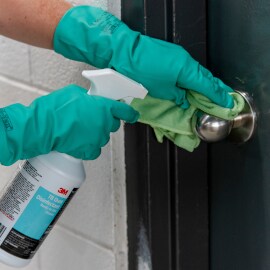 Person cleaning metal doorknob
