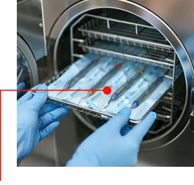 Các bề mặt hóa học được đưa vào nồi hấp bằng tay đeo găng y tế.