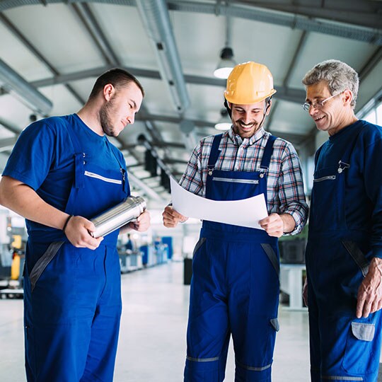 Ba người đàn ông đang làm việc trong một nhà máy