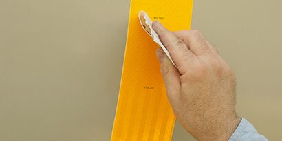 bàn tay của một người đàn ông đang dán băng keo phản quang 3M
