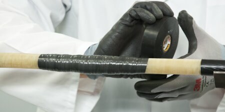 Worker wrapping cable in 3M Rubber Electrical tape to be used as primary insulation
