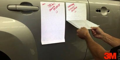 Một thợ dán đồ họa đang bóc lớp đế của tấm dán xe ra khỏi xe ô tô.
