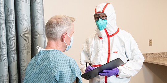 Bác sĩ mặc PPE khi nói chuyện với bệnh nhân
