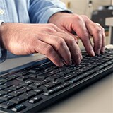 Hands using computer mouse and keyboard