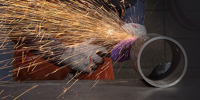 một người thao tác dụng cụ trên một vật hình trụ
