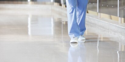 close up of employee walking on clean floor in health care facility
