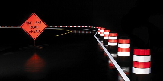 A road with traffic cones on the side
