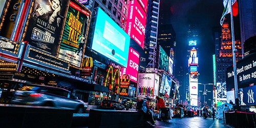 Thành phố sôi động đầy màu sắc với các bảng hiệu đèn neon trong bầu trời đêm
