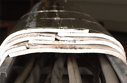 Mitigating fire damage in an oil refinery with 3M’s protective wrap system.
