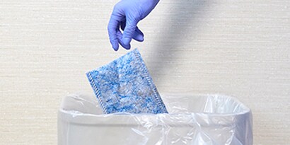 healthcare professional throwing away a disposable 3M easy clean floor mop pad