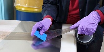 Công nhân sản xuất dán băng keo Polytetrafluoroethylene (PTFE) lên một bộ phận
