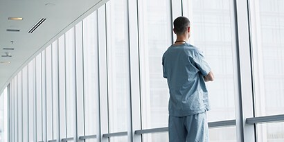 người đàn ông đang nhìn ra ngoài qua cửa sổ sạch sẽ
