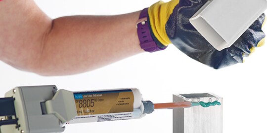 Technician in an assembly line plant creates an adhesive bond
