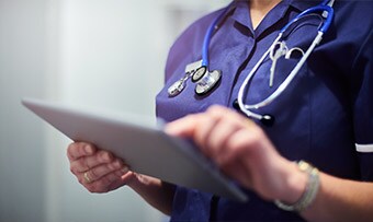 Hình minh họa: Chuyên viên y tế đang sử dụng máy tính bảng để chia sẻ thông tin tham khảo với bệnh nhân
