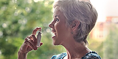 Woman using a mouth spray

