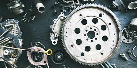 Các bánh răng, đai ốc và bu lông kim loại được sắp xếp trên bàn để lắp ráp.
