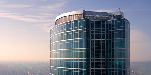 High-rise building with glass windows against clear day skies.

