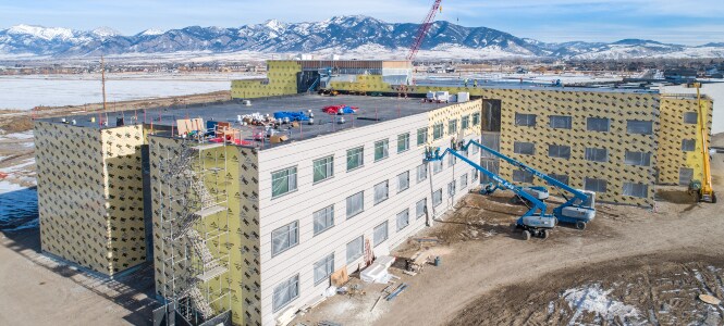 Image of buildings wrapped in an air barrier with external cladding completed on one wall