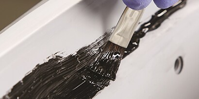 brushing seam sealer onto primed metal
