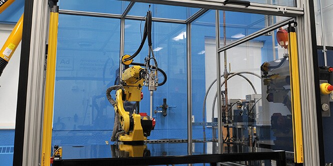 Hình ảnh một robot trong khu làm việc, lơ lửng trên một bàn làm việc phẳng
