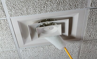 dusting tool being used in ceiling vents
