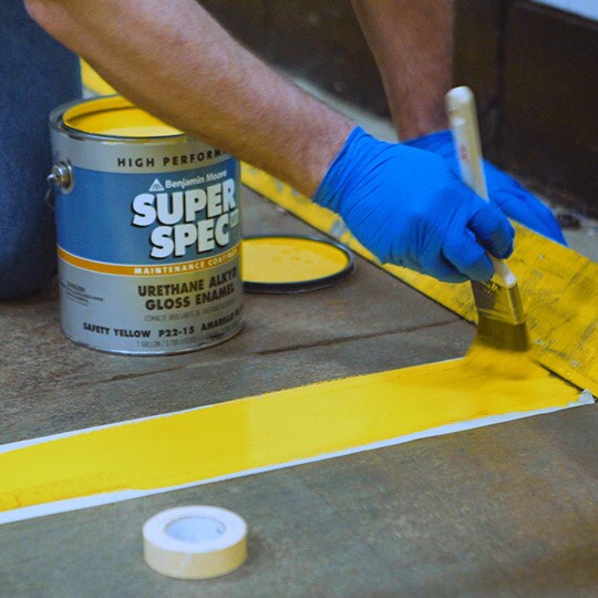 Person painting over floor tape