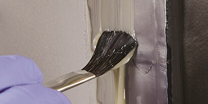 brushing seam sealer onto unprimed metal

