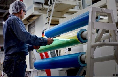Hình ảnh công nhân tháo tấm khuôn in Flexo ra khỏi tấm khuôn in Flexo trên trục quay
