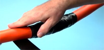Một người đàn ông sử dụng băng keo 3M màu đen để sửa chữa vỏ cáp điện.
